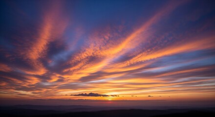Dramatic fiery sunset sky over dark mountain silhouettes landscape.
