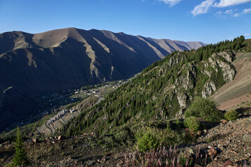 A village in a mountain gorge and a factory on the mountainside.
