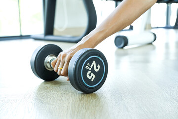 a woman in a blue workout outfit prepares to lift weights for exercise.