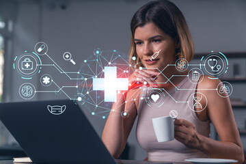 Thoughtful businesswoman in casual wear typing on laptop at office workplace with coffee cup. Concept of distant work, business, internet surfing, information technology. Medical icons hologram