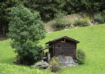 Historische Wassermühle in Südtirol – traditionelle Holzmühle inmitten grüner Almwiesen