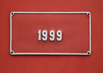 20th century 1999 th year one 1 red rectangular square frame is hanging on red painted wall with urban grunge historical background 1999 year produced