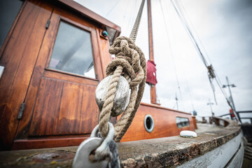 Obraz premium Artistic close-up of rope knot on fishing boat with mast in blur 