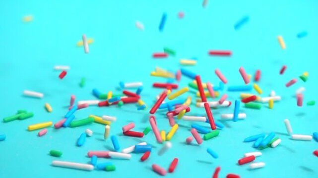 beautiful slow fall of bright sprinkles against tranquil blue backdrop, creating playful and charming scene for any project