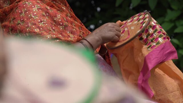 Closeup shot of Women doing hand embroidery. phulkari embroidery tradition of Punjab.