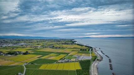 雨が降りそうな9月の富山県入善町沿岸からみる洋上風力発電風車をはじめとする様々なもの
