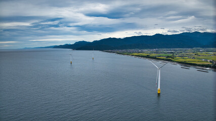 雨が降りそうな9月の富山県入善町沿岸からみる洋上風力発電風車をはじめとする様々なもの