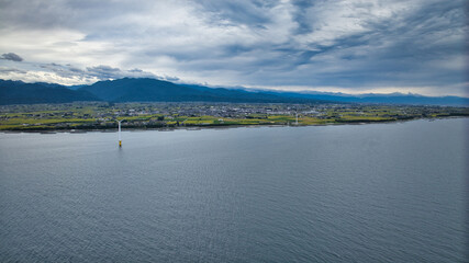 雨が降りそうな9月の富山県入善町沿岸からみる洋上風力発電風車をはじめとする様々なもの