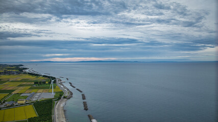 雨が降りそうな9月の富山県入善町沿岸からみる洋上風力発電風車をはじめとする様々なもの