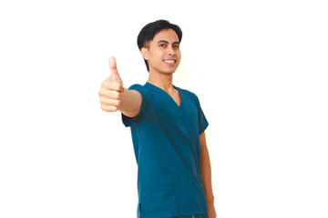 Smiling young male nurse in scrubs with stethoscope giving thumbs up gesture while looking at camera, isolated on white background, symbol of confidence and healthcare support.