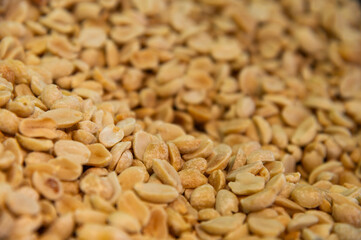 Lots of roasted peanuts as background, top view. Macro shot of peeled peanuts in large volume