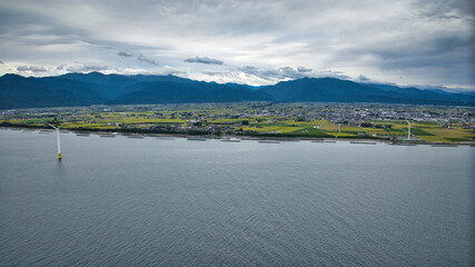 雨が降りそうな9月の富山県入善町沿岸からみる洋上風力発電風車をはじめとする様々なもの
