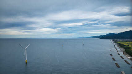 雨が降りそうな9月の富山県入善町沿岸からみる洋上風力発電風車をはじめとする様々なもの