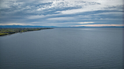 雨が降りそうな9月の富山県入善町沿岸からみる洋上風力発電風車をはじめとする様々なもの