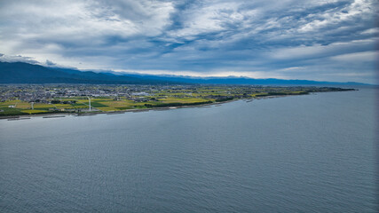 雨が降りそうな9月の富山県入善町沿岸からみる洋上風力発電風車をはじめとする様々なもの