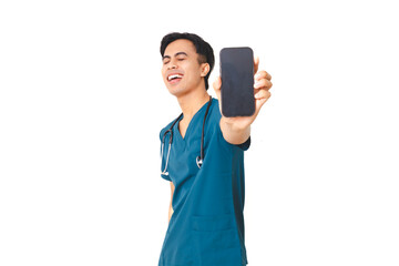 Happy young male nurse in scrubs with stethoscope smiling while holding a smartphone and showing its blank screen, isolated on white background for healthcare or tech concept.