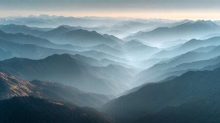 Obraz premium Panoramic view of endless blue mountain ranges layered in morning mist creating a serene and ethereal landscape