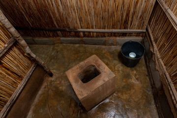 Raised Pit Latrine with Reed Walls and Cement Block Base, Improved Rural Sanitation Facility in African Village
