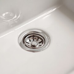 Woven laundry basket filled with neatly folded clean towels and blankets on a wooden shelf