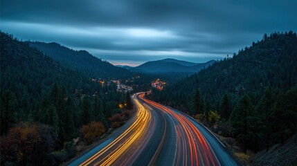 Night Road Through Mountain Valley with Light Streaks from Vehicles at Dusk or Twilight