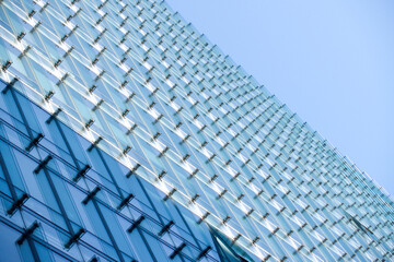 Fototapeta premium Close-up detail of modern glass wall with repetitive architectural pattern.