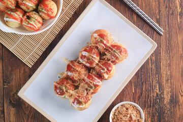Takoyaki is japanese street food with sauce, mayonaise and katsuobushi as topping and octopus filing, popular street food.
