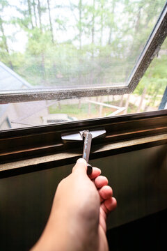 Hand Opening a Casement Window to the Outdoors