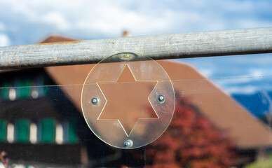 Star of David Cutout on Glass Panel and traditonal swiss house in Spiez