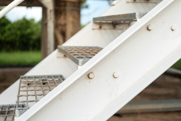 An overpass walkway across the production pipeline at the petrochemical and refinery plant. Industrial work place, close-up and selective focus.	