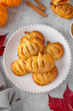 Naklejki Pumpkin mini pies or hand pies with glass of coffee on a stone background. Traditional autumn dessert for Halloween and Thanksgiving. Copy space
