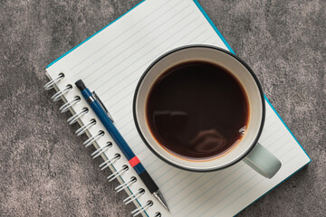 Top View of Coffee Cup on Notebook with Pen on Desk