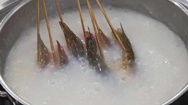 cooking shrimp skewers in cantonese congee hotpot
