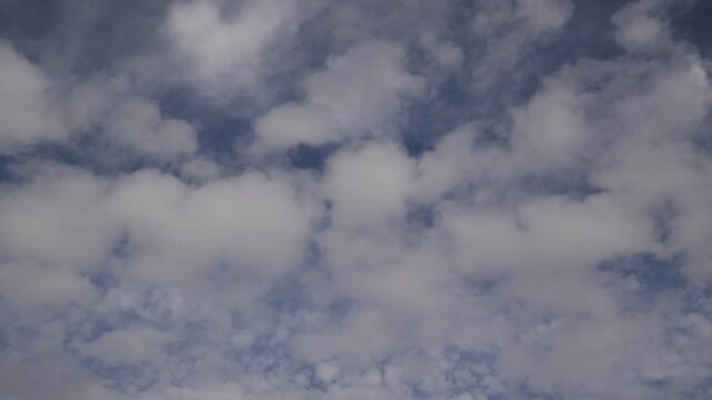 Low-angle time-lapse footage of the white clouds rolling in the blue sky during a sunny afternoon