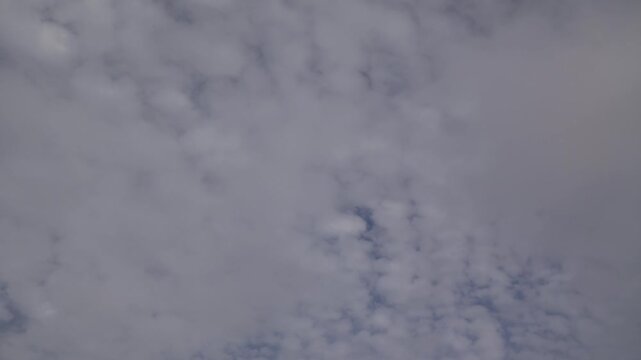 Time-lapse low-angle footage of the white clouds rolling in the blue sky during a sunny afternoon