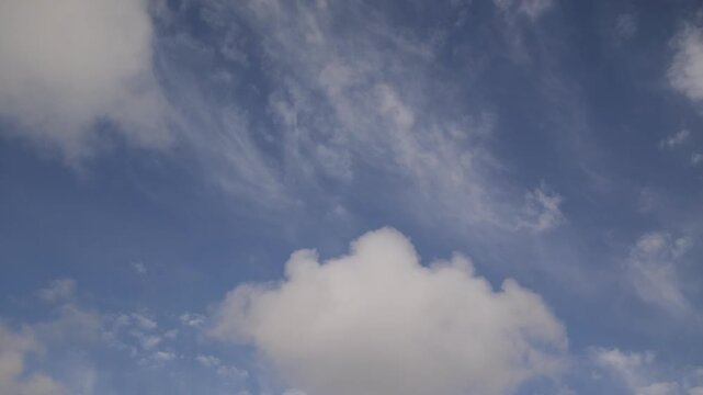 Time-lapse low-angle footage of the white clouds rolling in the blue sky during a sunny afternoon