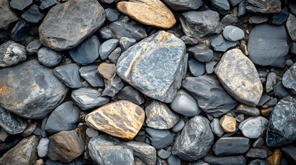 A close-up view of varied, textured stones in shades of gray and brown, displaying different shapes and patterns, creating a natural and earthy composition.