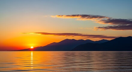 Obraz premium Serene Sunset Over Calm Water and Distant Mountains.
