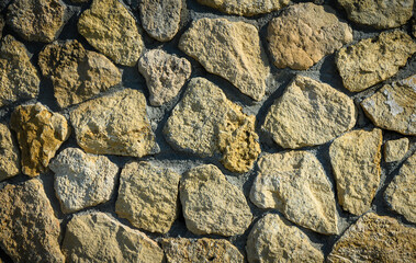 Natural Stone Wall with Sunlight Streaming Across Surface