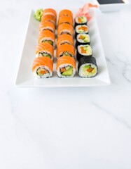 Variety sushi rolls on a white plate