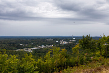 Panoramic view from Elliot Lake's fire tower, overlooking lush forests and the distant horizon under an overcast sky.