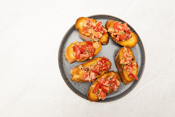 Top View of Baguette with Tomato, Cheese and Herbs on Plate with Copy Space