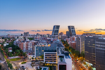 Aerial view of Madrid at dusk, looking from north to south, with the city bathed in warm twilight tones. 