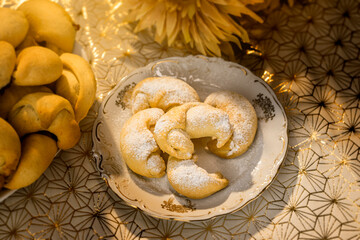Delicious baked goods, rolled croissants with homemade jam, placed on a white plate and dusted with white powdered sugar. Sweet treats, home-made confectionery.