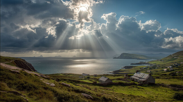 Sunbeams break through clouds over a coastal landscape with green fields and cottages leading to a calm ocean, suggesting a serene rural setting by the sea.
