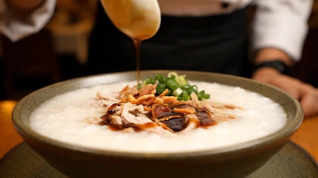 Chef Drizzling Sauce on Chicken Congee