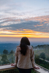 Golden hour tranquility, a lone figure captures a serene sunrise over misty mountains.