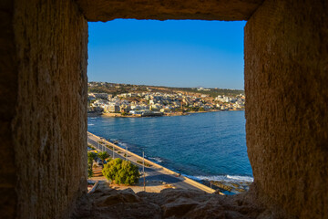 Greece, Rethimno, 05.09.2025: coastal city view with waterfront promenade, blue sea and hillside buildings