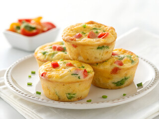 Healthy Egg Muffins Stacked on Plate with Vegetable Salad in Background
