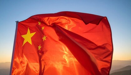 Chinese Flag Waving Against a Gradient Sky at Sunset Over Mountains