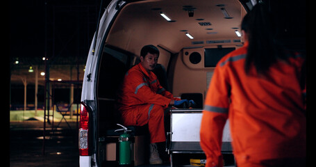 Emergency medical technician (EMT) team or paramedic nurse walking to ambulance car